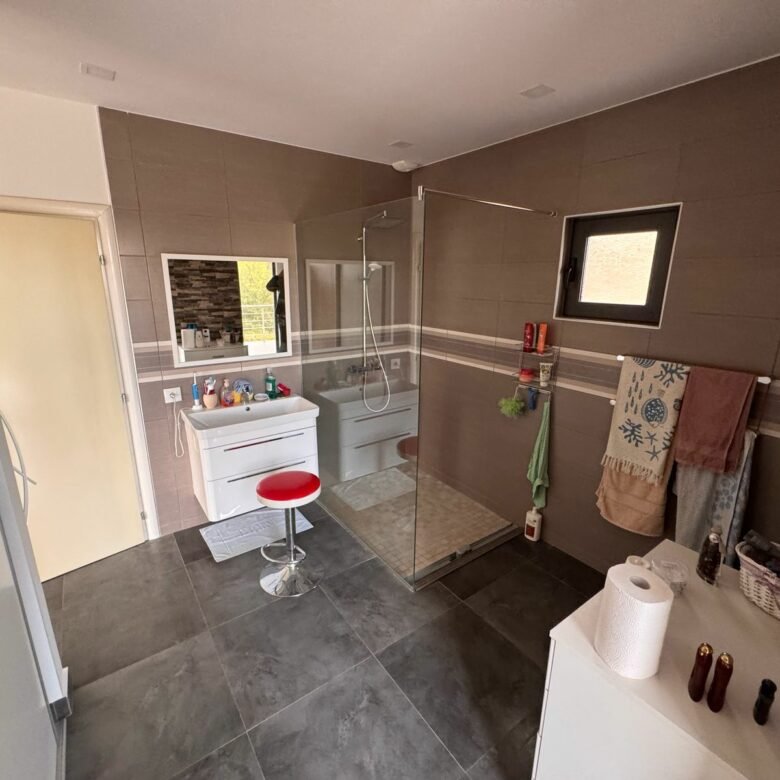 Elegant modern bathroom in Ulcinj with gray tile, glass shower, stylish vanity&mdash;exclusive at immorenta.me by ekosphere doo.