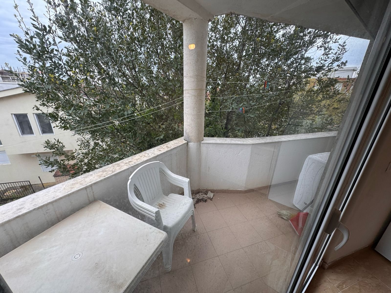 Charming Ulcinj balcony with tiled floor, outdoor seating, laundry space & scenic views&mdash;ideal Ulcinj property at immorenta.me.