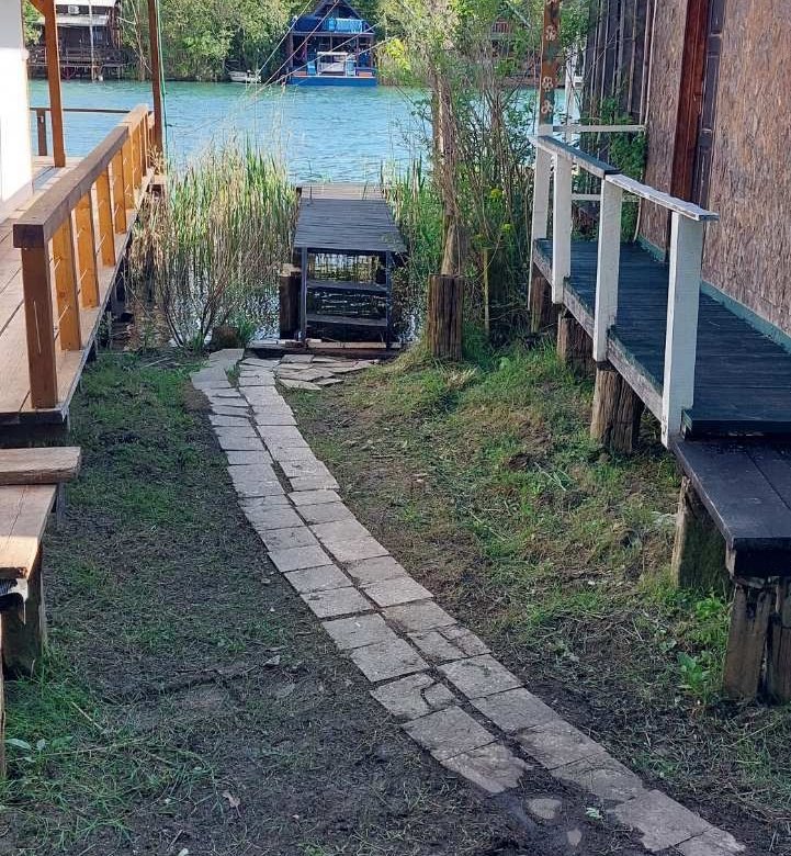 Charming Ulcinj riverfront real estate with stone path, dock, and scenic views&mdash;ideal property investment via immorenta.me by ekosphere doo.