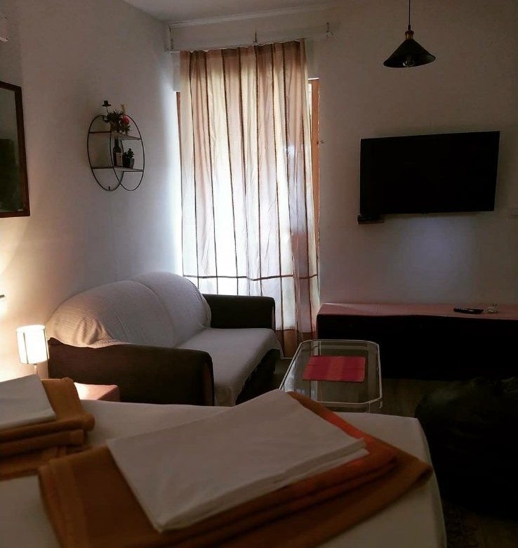 Modern living room in Ulcinj, Montenegro with a sofa, TV, and chic accents&mdash;exclusive investment on immorenta.me by Ekosphere.