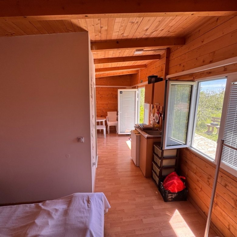 Charming wooden cabin in Ulcinj, Montenegro: cozy bed, sunlit interior, ideal investment via immorenta.me by Ekosphere.