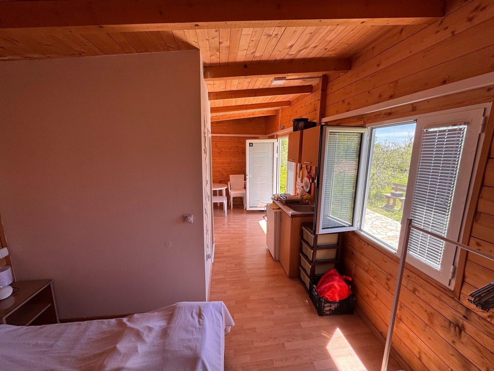 Charming wooden cabin in Ulcinj, Montenegro: cozy bed, sunlit interior, ideal investment via immorenta.me by Ekosphere.