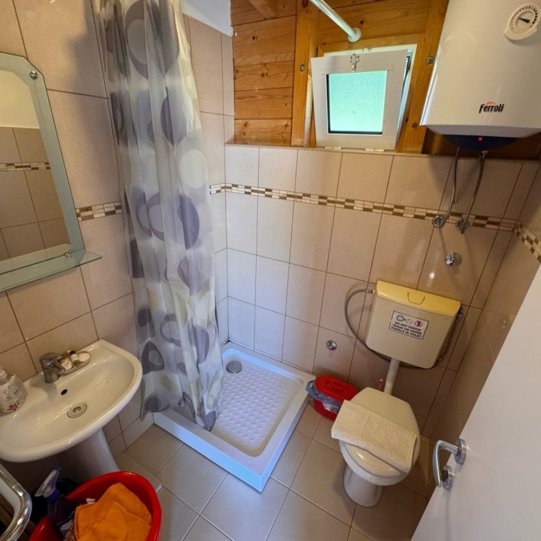 Modern eco-friendly Ulcinj bathroom with corner shower, beige tiles, quality fixtures. Invest in Montenegro at immorenta.me.