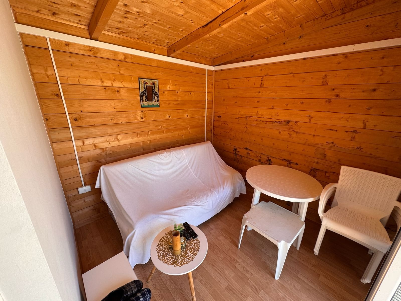 Charming Ulcinj property for sale: sunlit wooden room, stylish furnishings, exclusive on immorenta.me by Ekosphere DOO.