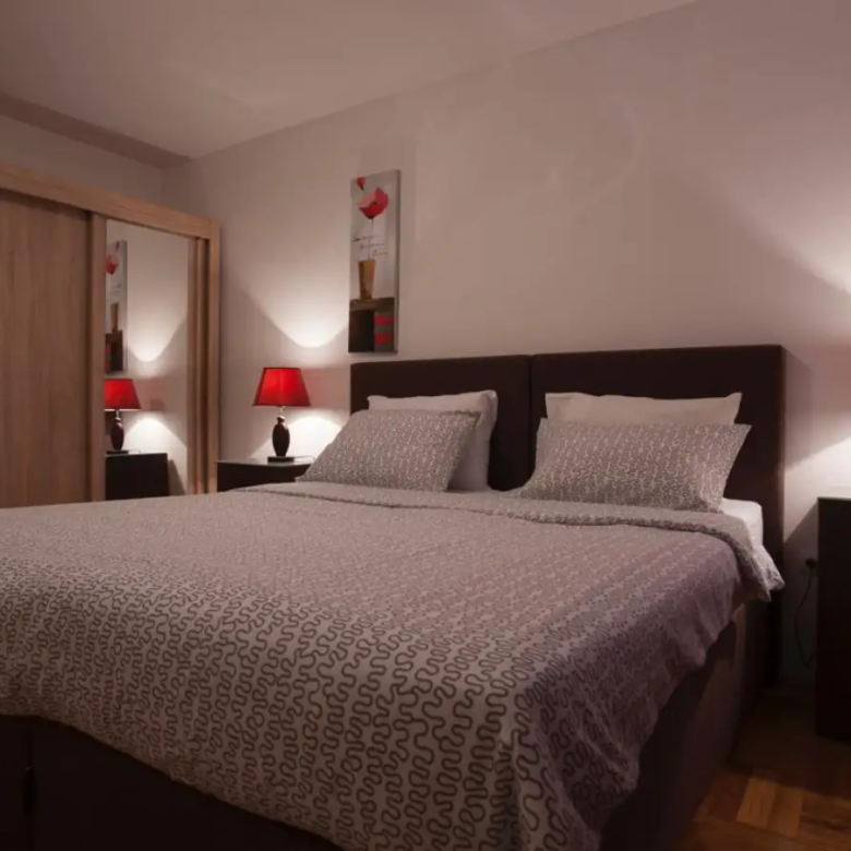 Modern Ulcinj bedroom: elegant gray bedding, stylish d&eacute;cor, and ample storage&mdash;ideal Montenegro real estate by Ekosphere on immorenta.me.