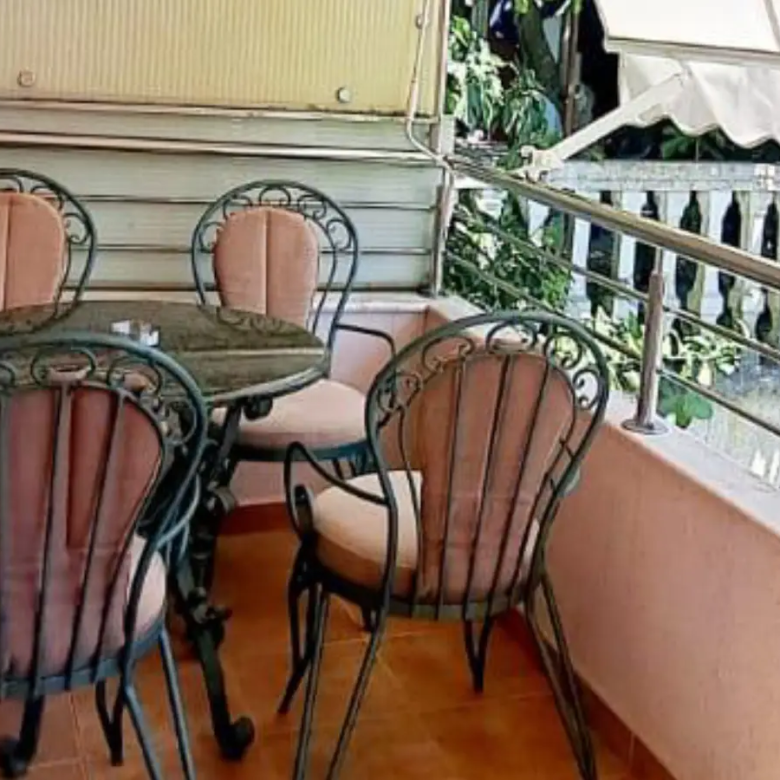 Elegant Ulcinj balcony with stone table, cushioned chairs, tiled floor, lush greenery&mdash;ideal property at immorenta.me by ekosphere doo.