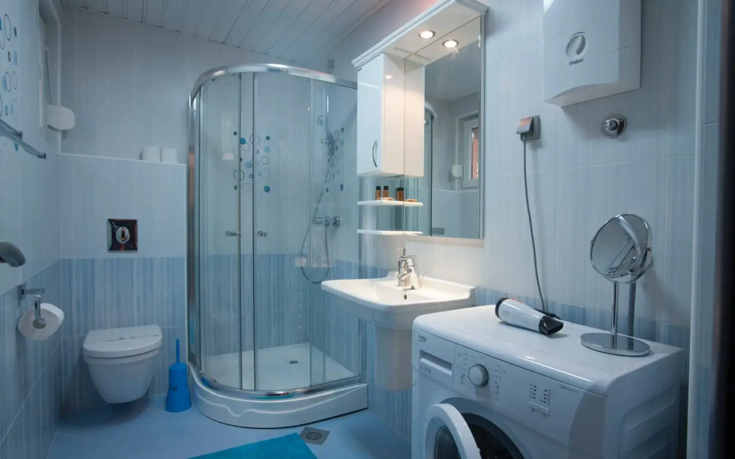 Contemporary Ulcinj bathroom: glass shower, modern fixtures, washing machine. Invest in Montenegro with immorenta.me by ekosphere doo.