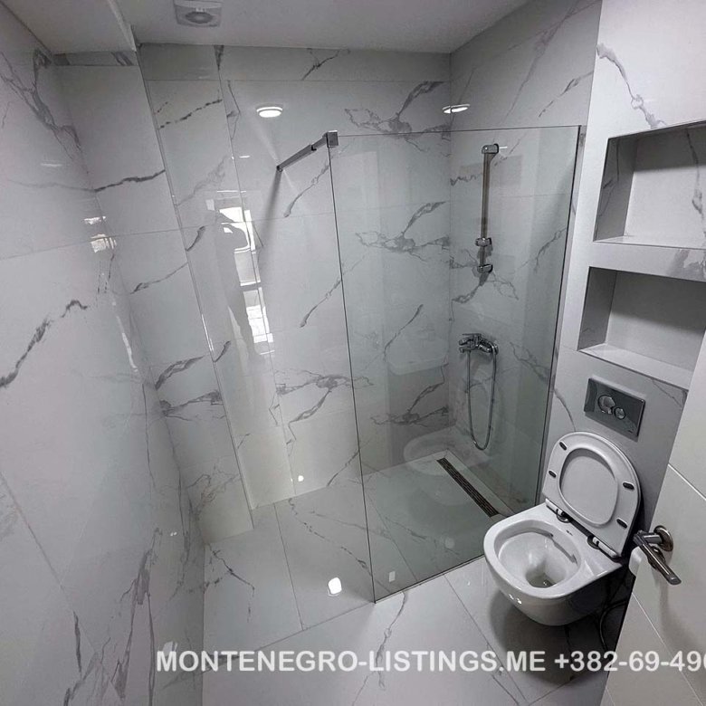 Luxurious Ulcinj bathroom with marble tiles, walk-in glass shower, and modern fixtures&mdash;exclusive at immorenta.me by Ekosphere doo.