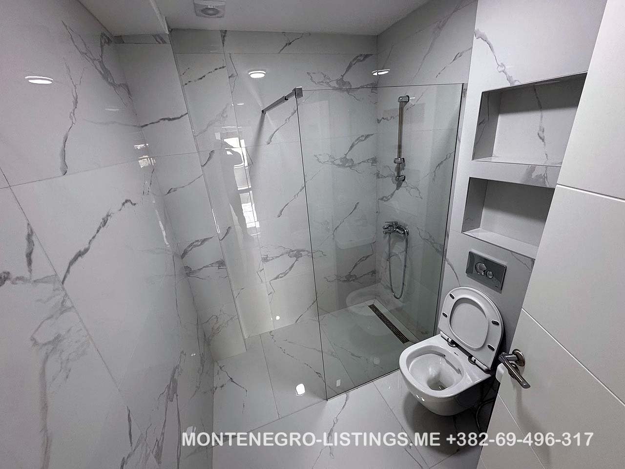 Luxurious Ulcinj bathroom with marble tiles, walk-in glass shower, and modern fixtures&mdash;exclusive at immorenta.me by Ekosphere doo.