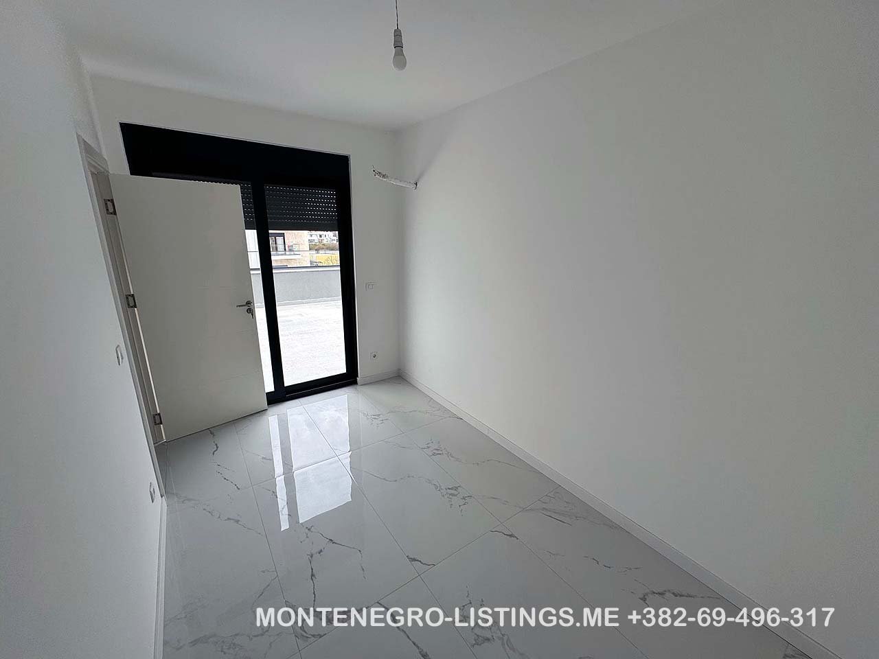 Bright, modern room in Ulcinj featuring white walls, marble tile, large window. Listed on immorenta.me by ekosphere doo.