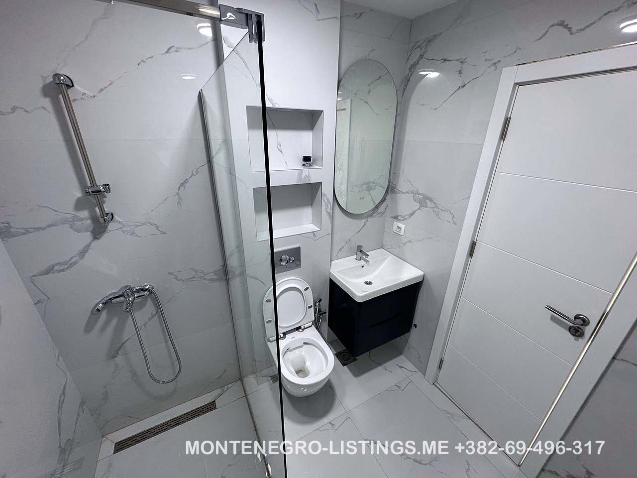Elegant Ulcinj bathroom: marble tiles, glass shower, wall toilet, modern vanity&mdash;exclusive on immorenta.me by ekosphere doo.