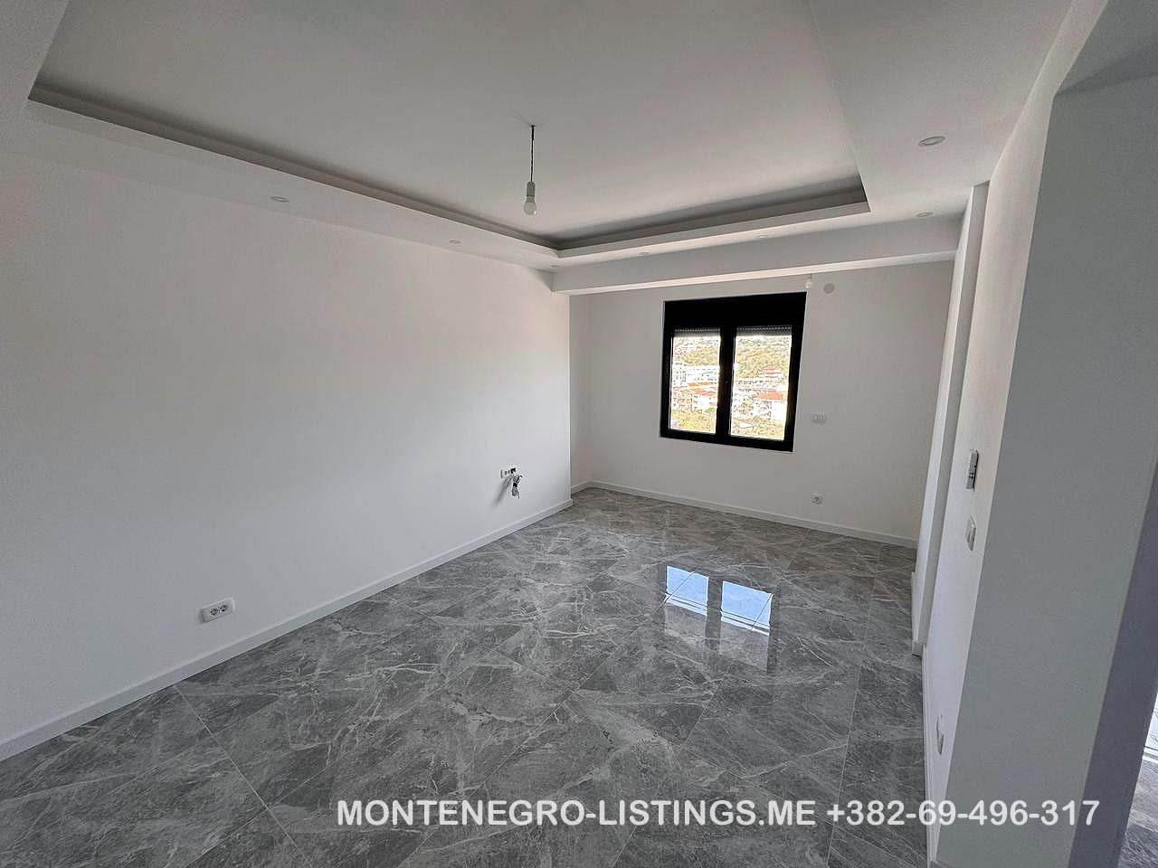 Bright unfurnished room with marble floors, recessed ceiling, and modern window in Ulcinj. Invest now via immorenta.me by Ekosphere DOO.