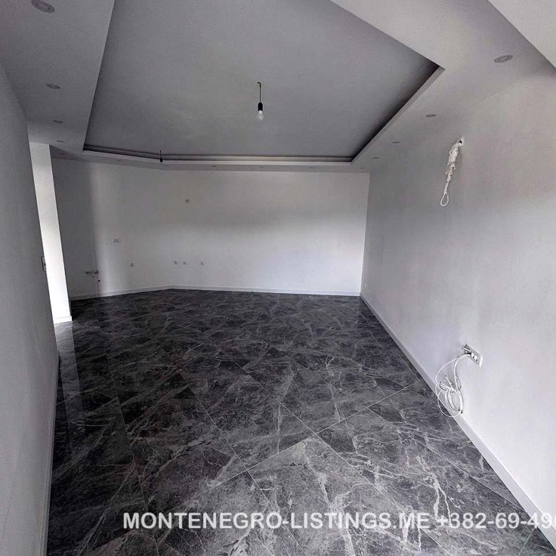 Spacious, modern room in Ulcinj with white walls, marble floors, and recessed lights&mdash;exclusive property at immorenta.me.