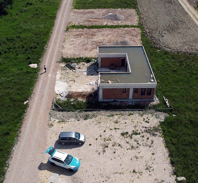 Prime aerial view of an unfinished brick property on spacious land in Ulcinj, Montenegro&mdash;ideal for investors via immorenta.me.