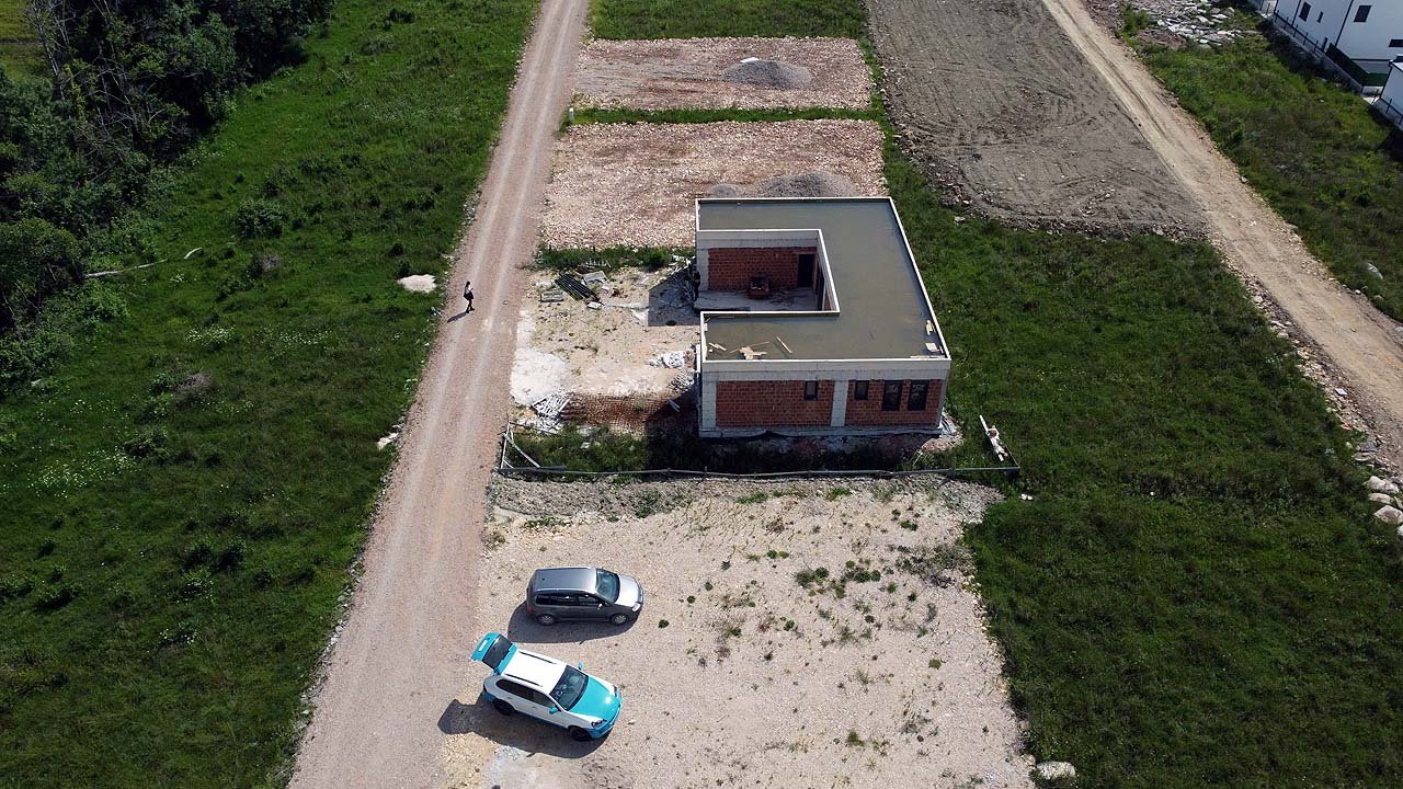 Prime aerial view of an unfinished brick property on spacious land in Ulcinj, Montenegro&mdash;ideal for investors via immorenta.me.