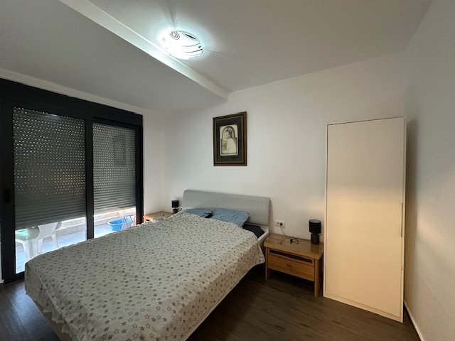 Modern Ulcinj property with a stylish bed, two wooden nightstands, large windows; exclusive listing by immorenta.me ekosphere doo.