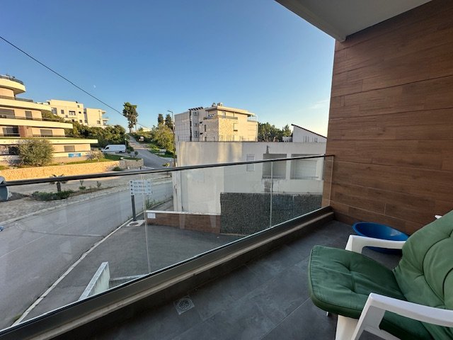 Modern balcony with glass railing, stylish seating and table, overlooking prime Ulcinj real estate&mdash;Exclusive at immorenta.me by Ekosphere DOO.