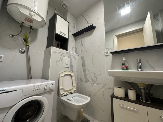 Modern Ulcinj bathroom with washer, heater, marble tiles&mdash;smart real estate investment by Ekosphere on immorenta.me.