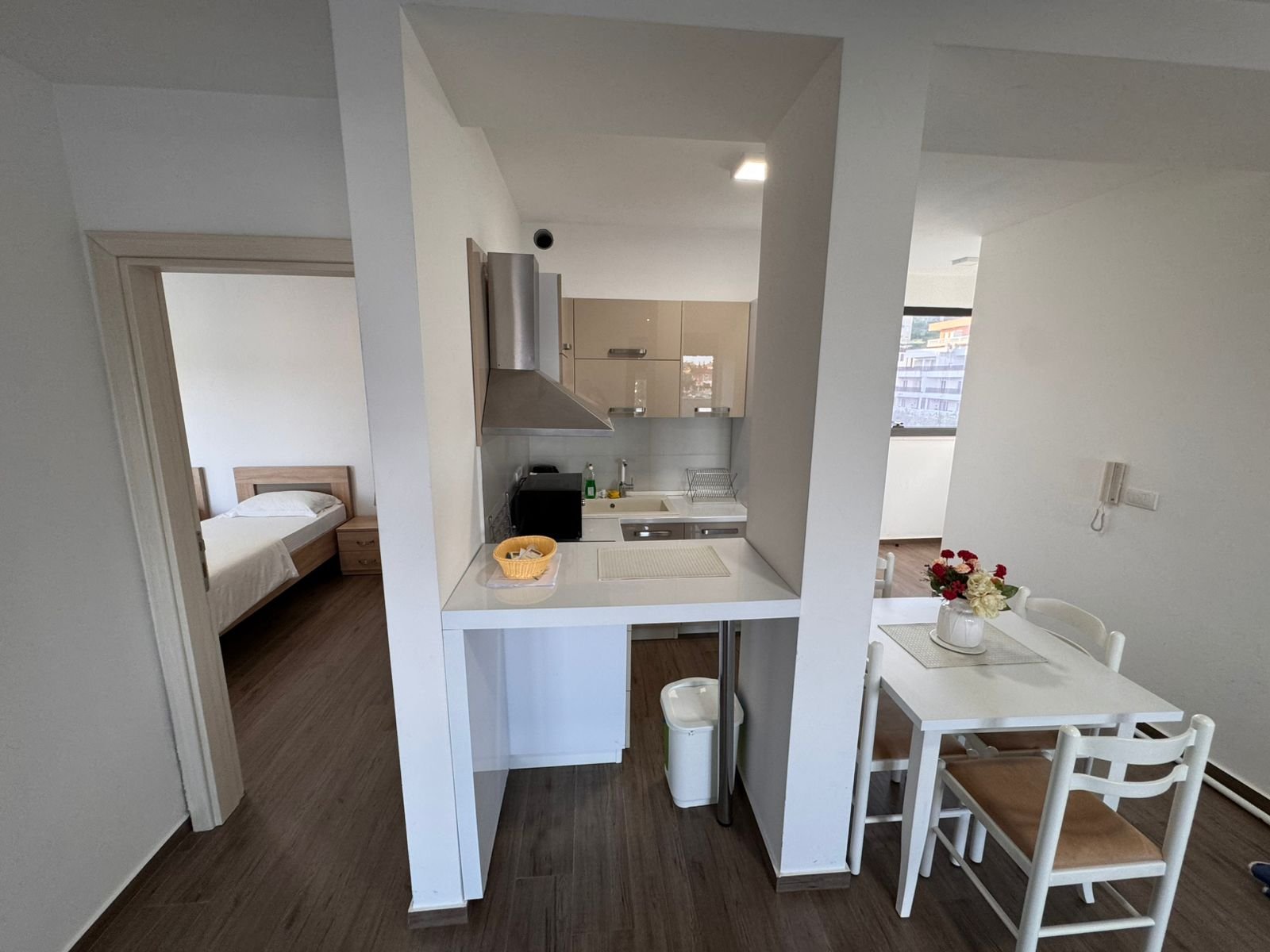 Modern kitchen with white cabinets, dining for four, leads to bedroom&mdash;ideal Ulcinj investment. Exclusively by immorenta.me.