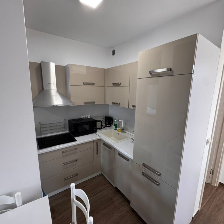 Stylish compact kitchen in Ulcinj with beige cabinets, premium appliances, dining area&mdash;ideal Montenegro real estate by ekosphere doo.