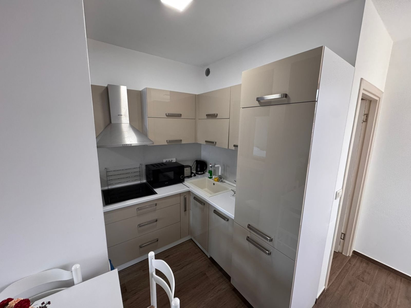 Stylish compact kitchen in Ulcinj with beige cabinets, premium appliances, dining area&mdash;ideal Montenegro real estate by ekosphere doo.
