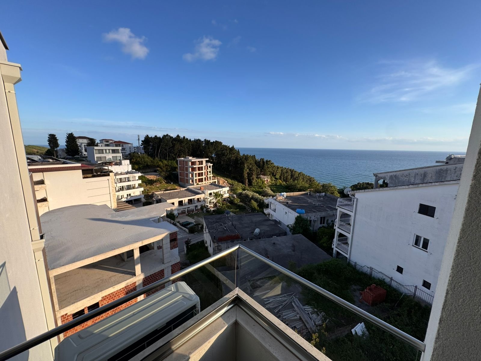 Premium balcony views of Ulcinj real estate&mdash;white homes, lush hills, distant blue sea. Invest with immorenta.me by ekosphere doo.