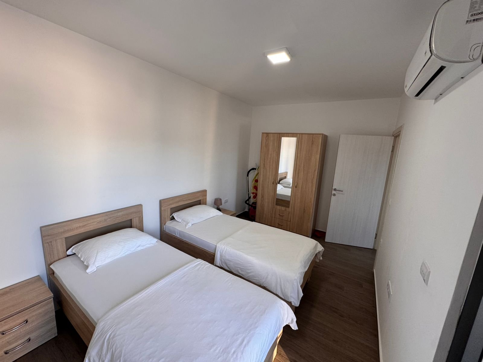 Invest in Ulcinj, Montenegro: stylish bedroom with twin beds, wood floors, AC. Listed by immorenta.me&mdash;ekosphere doo project.