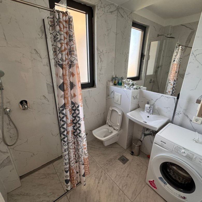 Modern Ulcinj Montenegro bathroom with marble tiles, bright windows, washer; ideal property investment. immorenta.me by ekosphere doo.