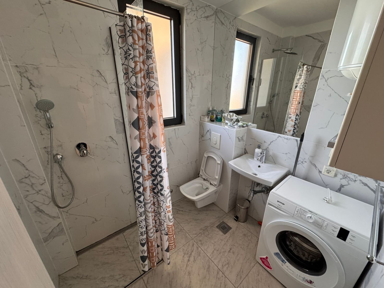 Modern Ulcinj Montenegro bathroom with marble tiles, bright windows, washer; ideal property investment. immorenta.me by ekosphere doo.