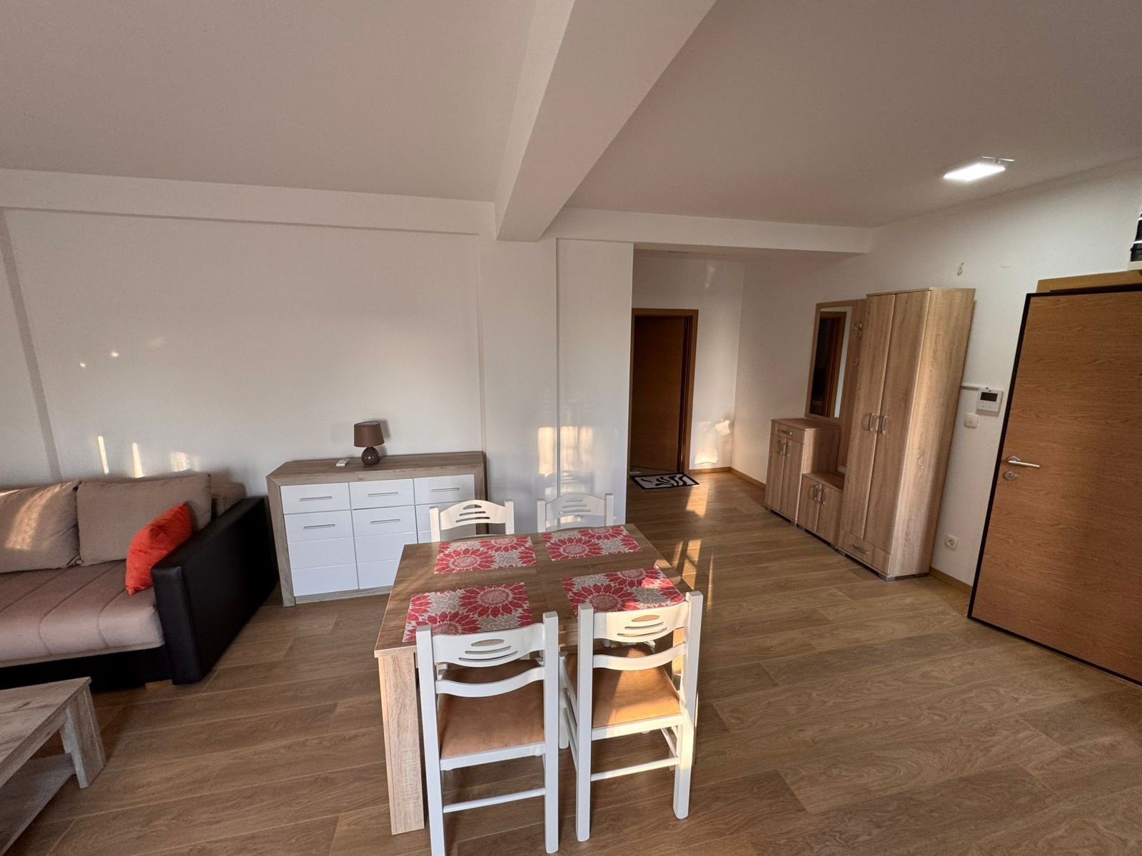 Elegant dining area with wooden table, sideboard, and sofa, ideal Ulcinj investment. Montenegro-listings.me by ekosphere doo.