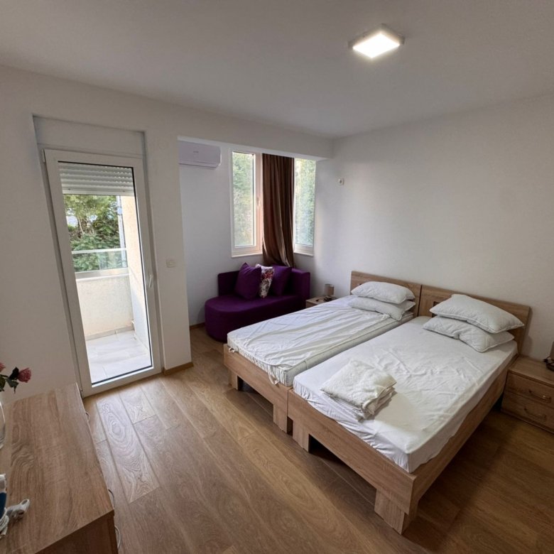 Elegant Ulcinj bedroom with twin beds, purple sofa, balcony & lush views. Prime real estate by Ekosphere on immorenta.me.