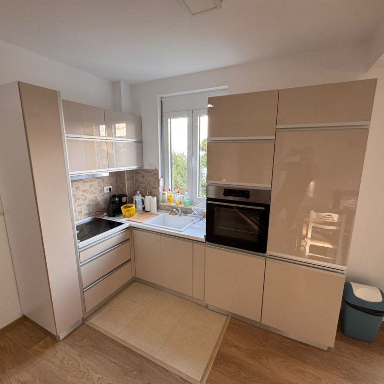 Stylish modern kitchen in Ulcinj with beige cabinets, built-in oven, and wooden flooring&mdash;exclusive on immorenta.me by ekosphere doo.