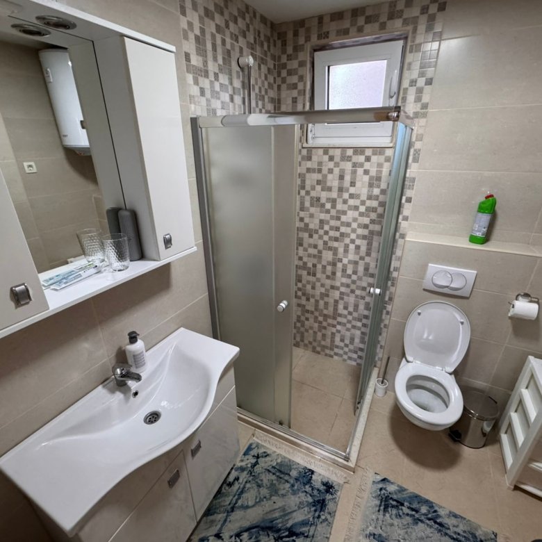 Modern compact bathroom in Ulcinj property with sleek fixtures, glass shower, and Ekosphere accents&mdash;exclusive at immorenta.me.