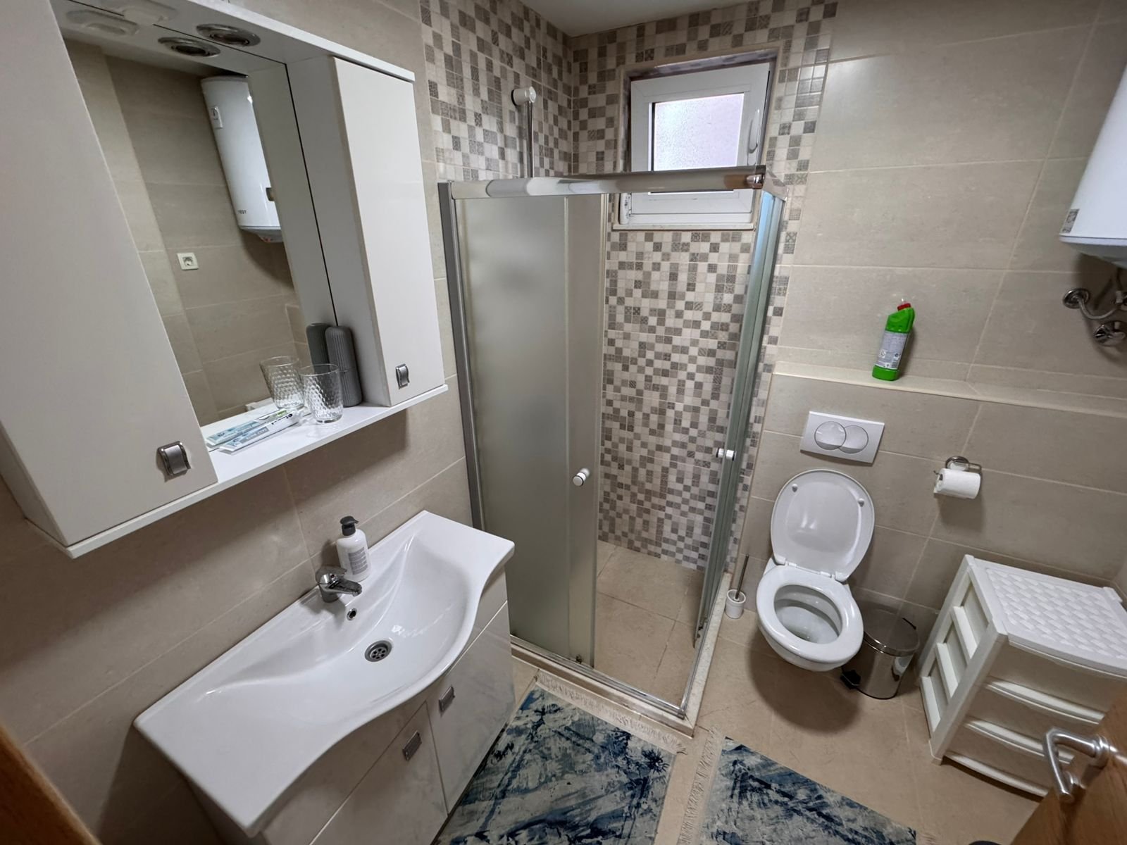 Modern compact bathroom in Ulcinj property with sleek fixtures, glass shower, and Ekosphere accents&mdash;exclusive at immorenta.me.