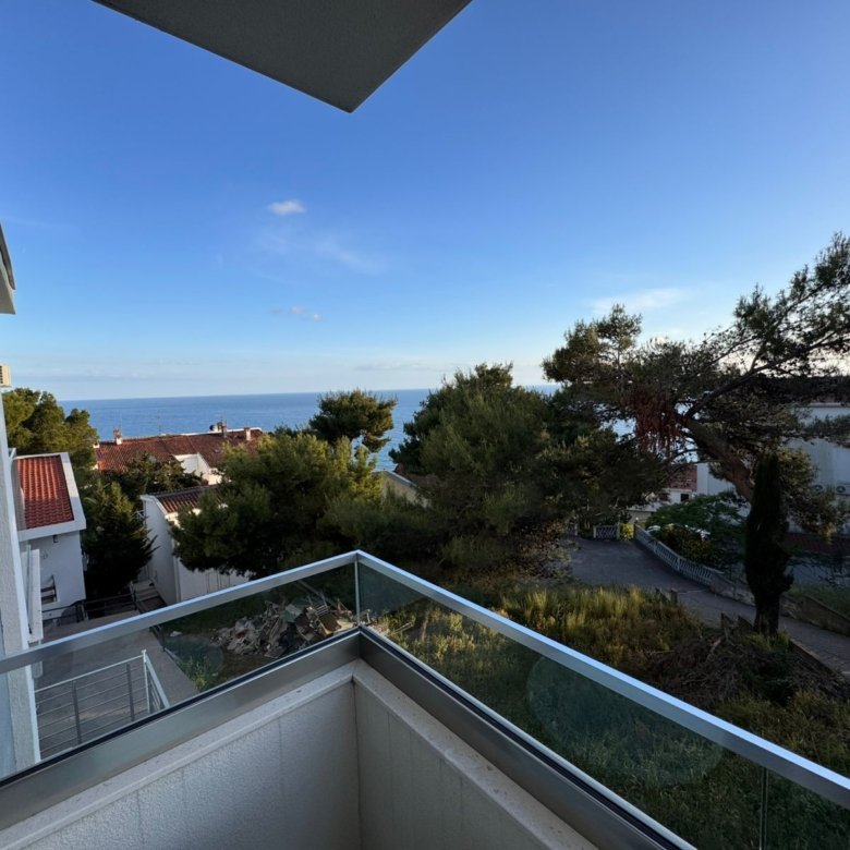 Stunning glass-railed balcony view over sea, rooftops, and greenery&mdash;prime Ulcinj Montenegro property at immorenta.me by Ekosphere doo.