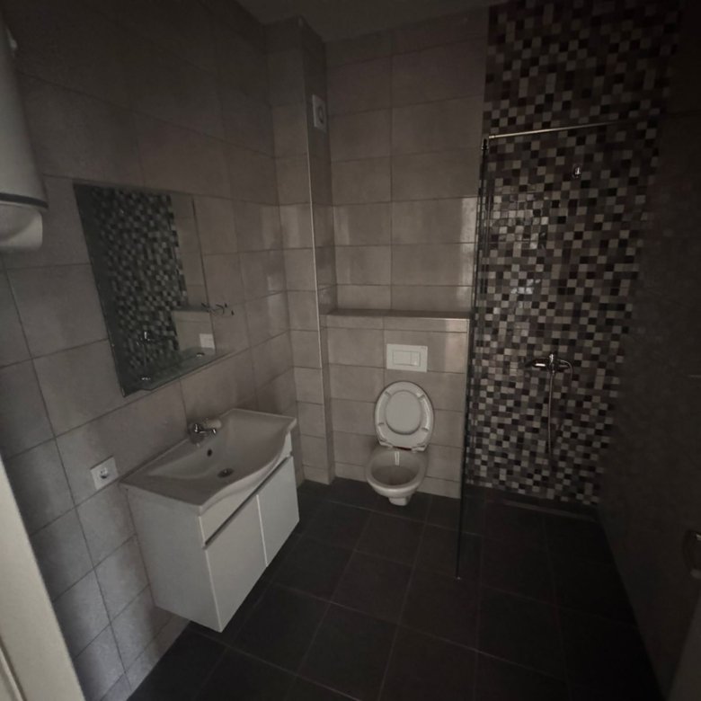 Stylish modern bathroom in Ulcinj real estate&mdash;tiled walls, sleek fixtures, walk-in shower. Invest with ekosphere doo & immorenta.me!.