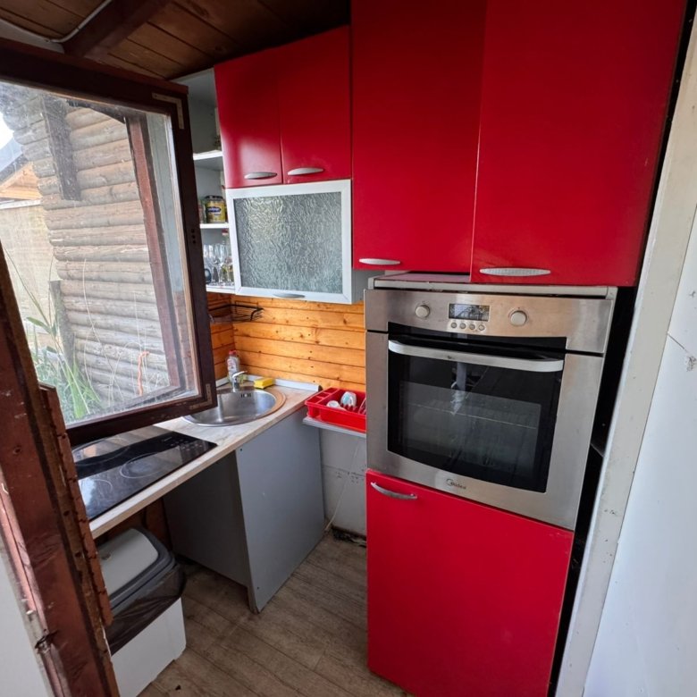 Chic Ulcinj kitchen: red cabinets, stainless oven, wood accents. Bright and inviting. Exclusive on immorenta.me by Ekosphere doo.