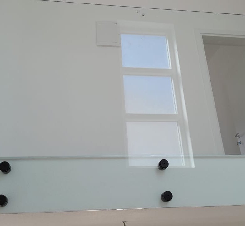 Modern glass railing with black hardware, sleek white wall, door, and window&mdash;ideal Ulcinj investment. Exclusive on immorenta.me by ekosphere doo.