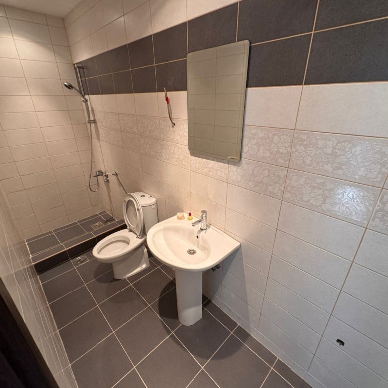 Modern Ulcinj Montenegro property bathroom: tiled in gray and white, with shower, sink, and mirror. Discover more on immorenta.me by ekosphere doo.