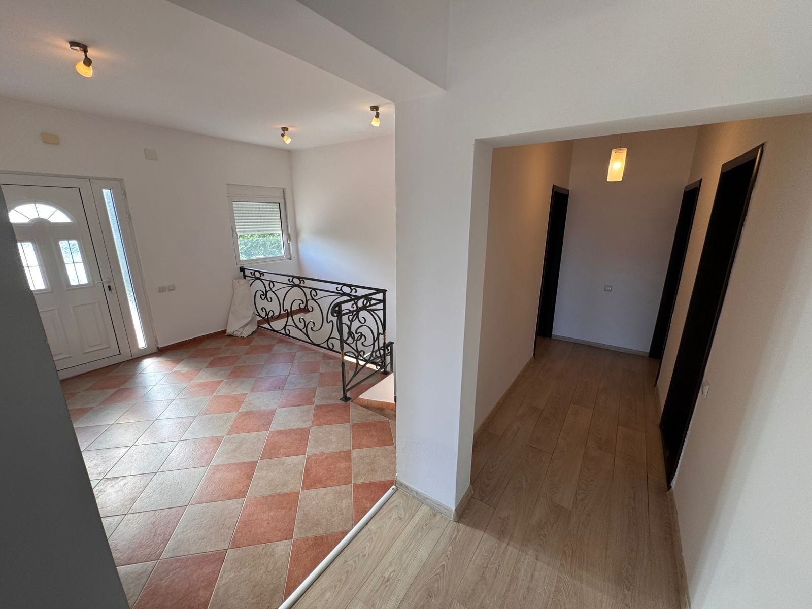 Sunlit entryway with tiled floor, elegant railings, and wood-floored hallway&mdash;prime Ulcinj real estate by immorenta.me/Ekosphere doo.