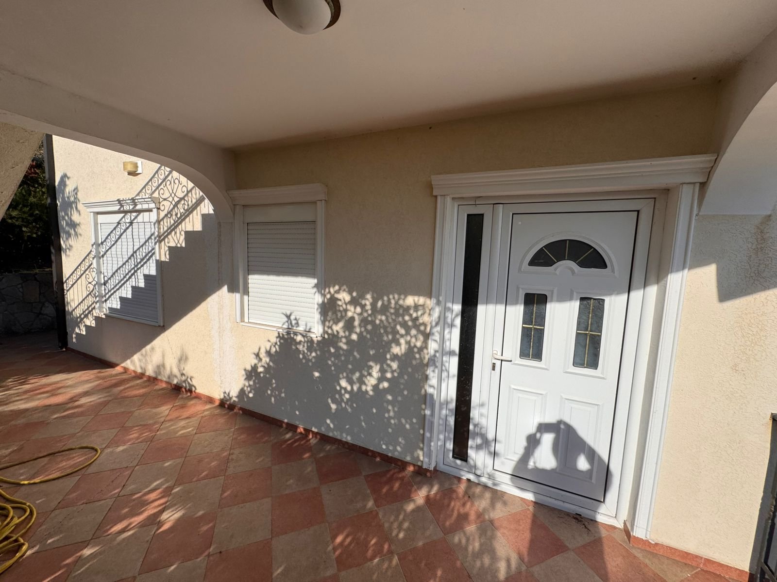 Modern white front door with glass panel and tiled entry, ideal Ulcinj real estate by ekosphere doo via immorenta.me.