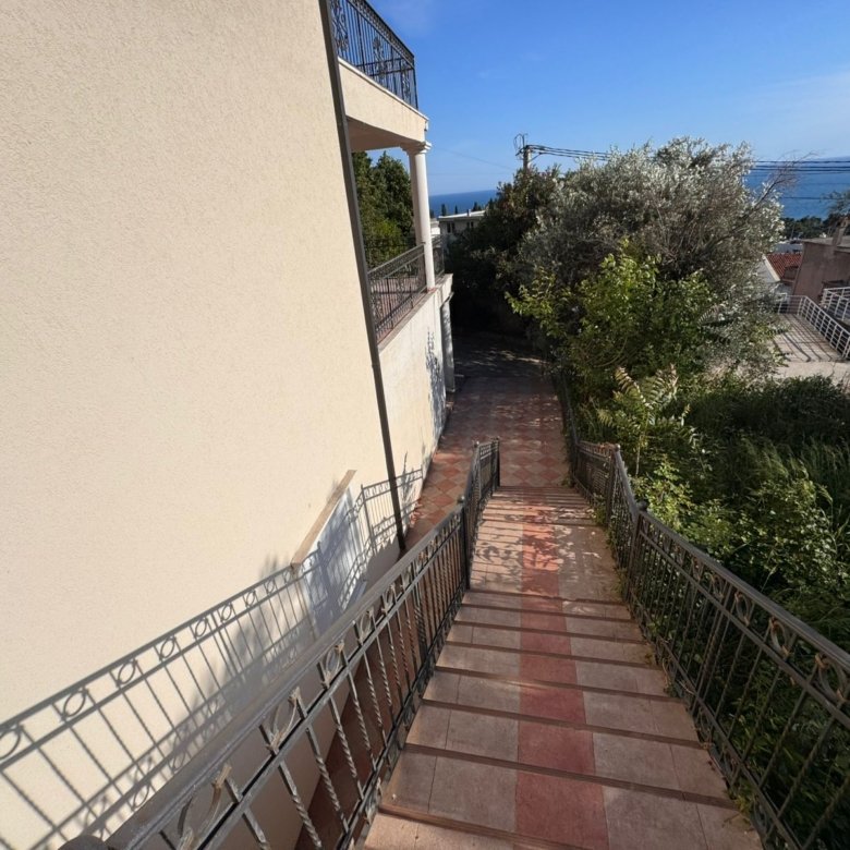 Modern sloped walkway with metal railing by a stylish building, lush greenery, sea views&mdash;prime Ulcinj investment. Eksophere doo project.
