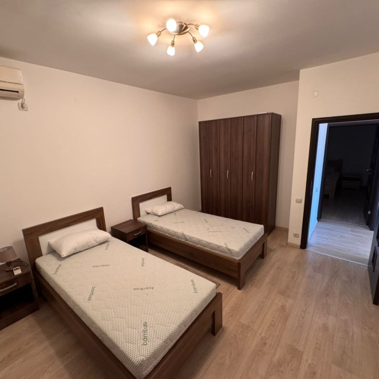 Modern Ulcinj bedroom with two single beds, wood flooring, AC, wardrobe&mdash;ideal Montenegro investment via immorenta.me.