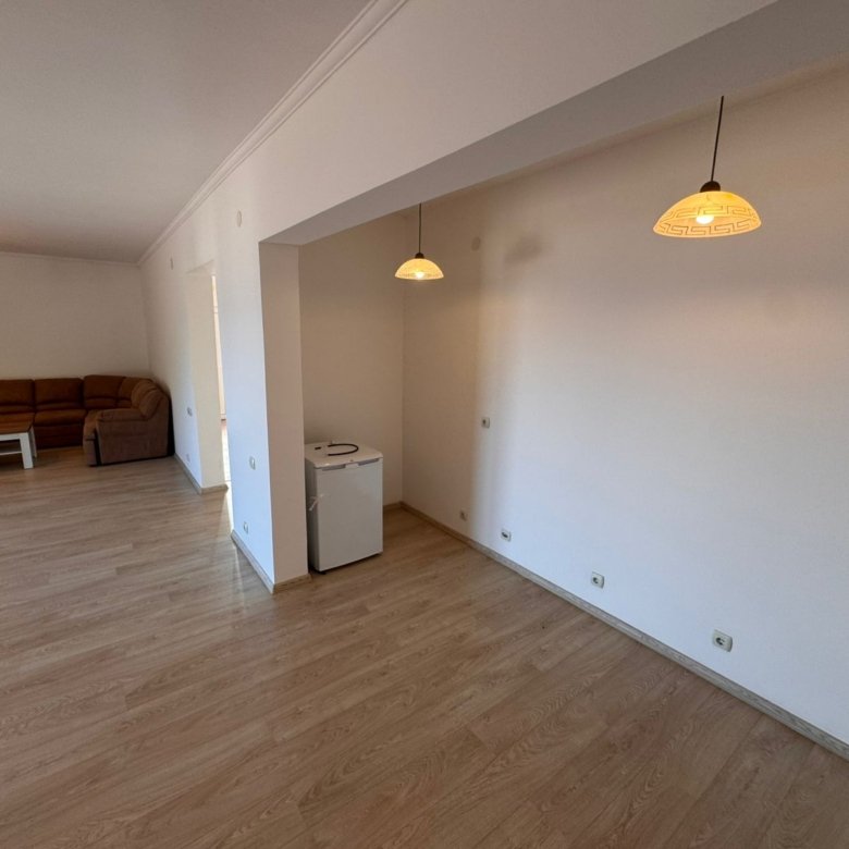 Spacious unfurnished room in Ulcinj with light wood floors, white walls, modern lighting; ideal Montenegro investment by ekosphere doo.