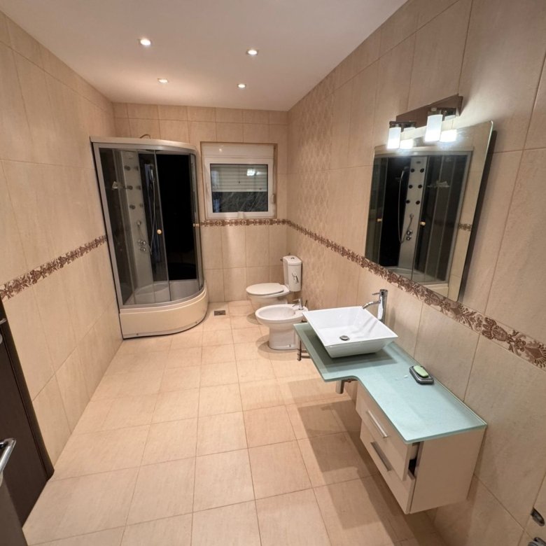 Elegant Ulcinj bathroom: beige tiles, glass shower, premium fixtures&mdash;ideal property investment on immorenta.me by ekosphere doo.