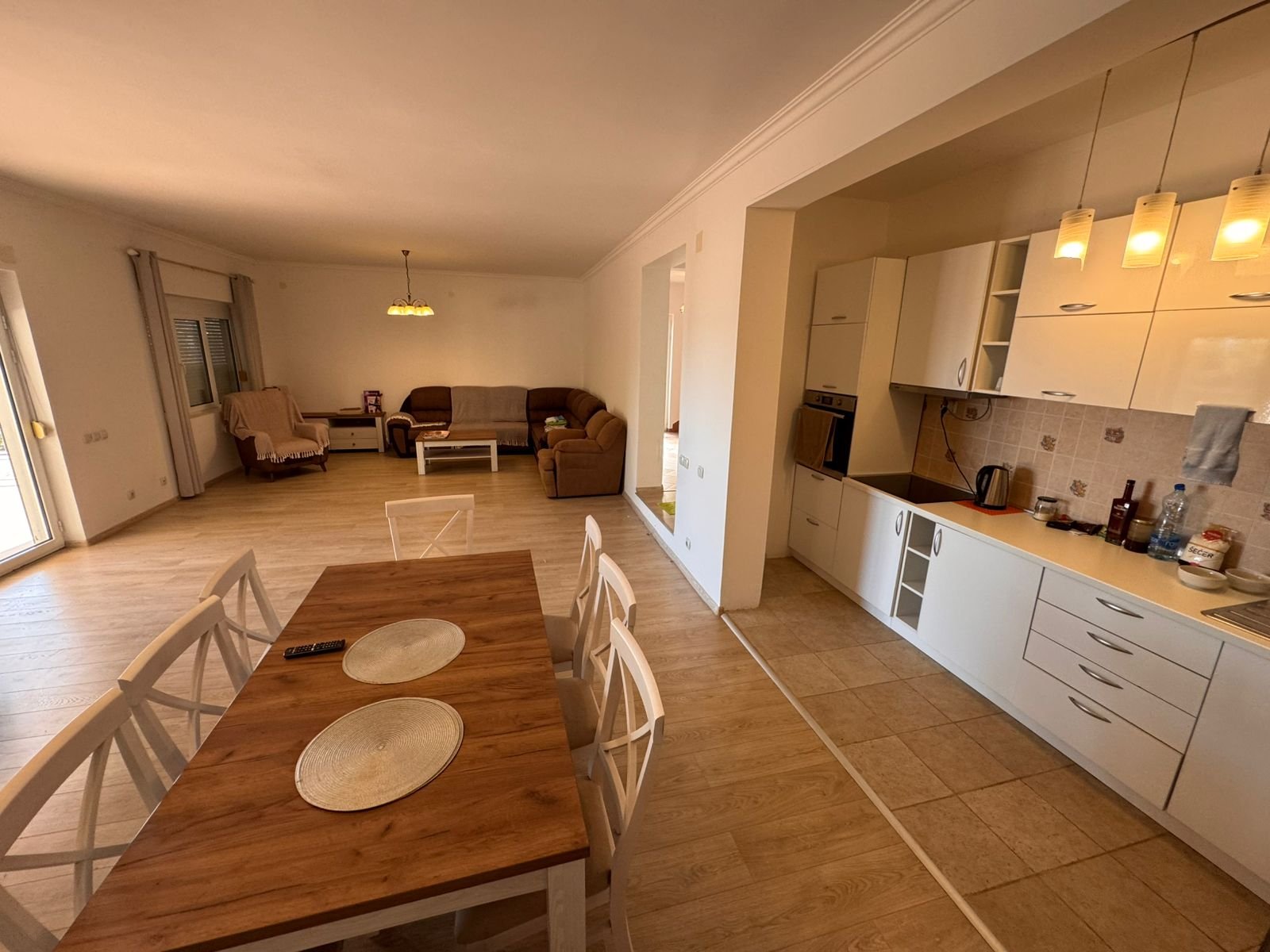 Luxurious open-plan living in Ulcinj, Montenegro&mdash;modern kitchen, central dining, light wood floors. Invest with immorenta.me by ekosphere doo.