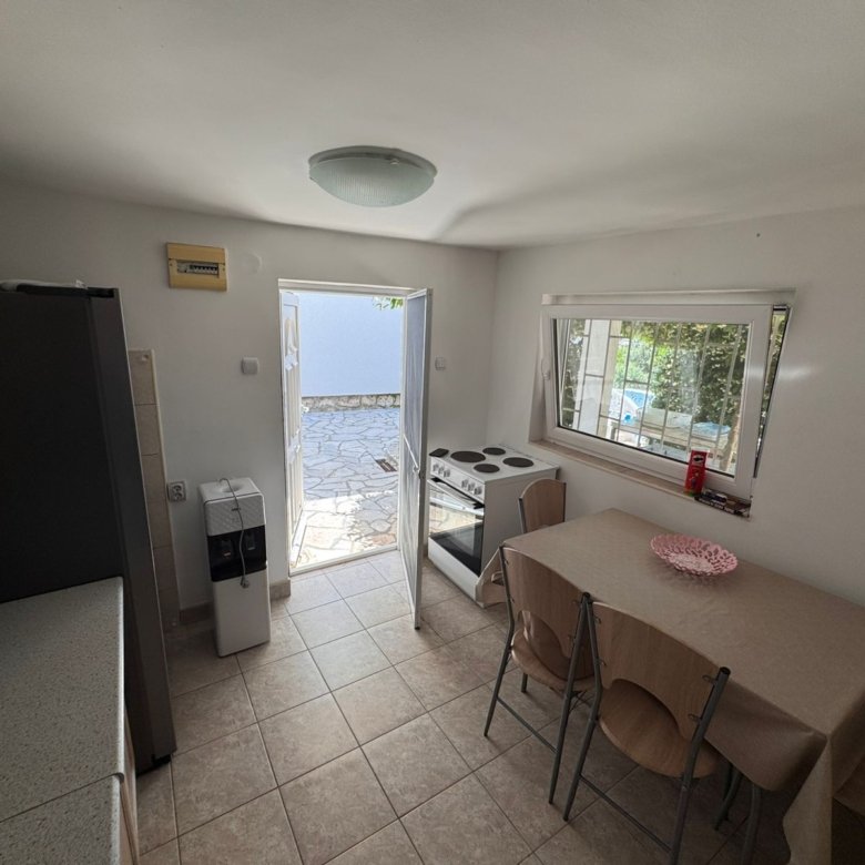 Charming Ulcinj kitchen with dining area, appliances & stone patio access. Ideal Montenegro property by Ekosphere doo via immorenta.me.