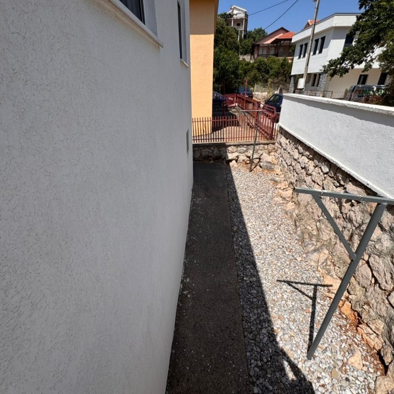 Prime Ulcinj property: gravel walkway & concrete path between buildings, metal structure, stone wall&mdash;exclusive at immorenta.me by ekosphere doo.