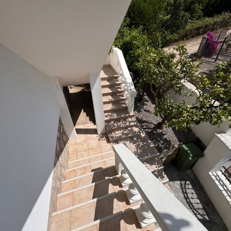 Inviting tiled staircase with white railings leads to lush garden&mdash;prime investment in Ulcinj. Listed by ekosphere doo at immorenta.me.