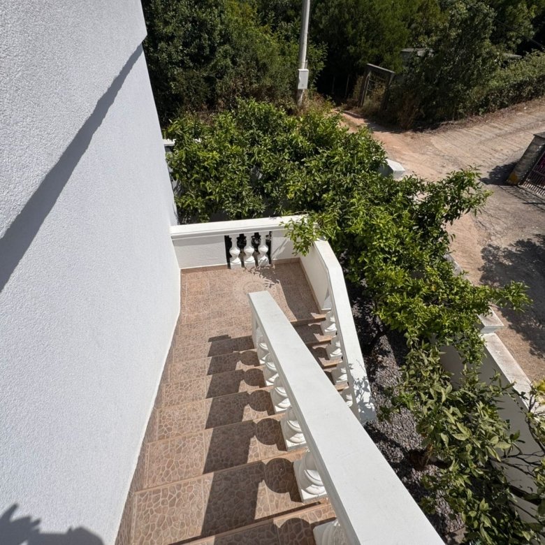 Modern outdoor staircase with white railings, brown tiles, and lush greenery&mdash;prime Ulcinj property via immorenta.me by Ekosphere.